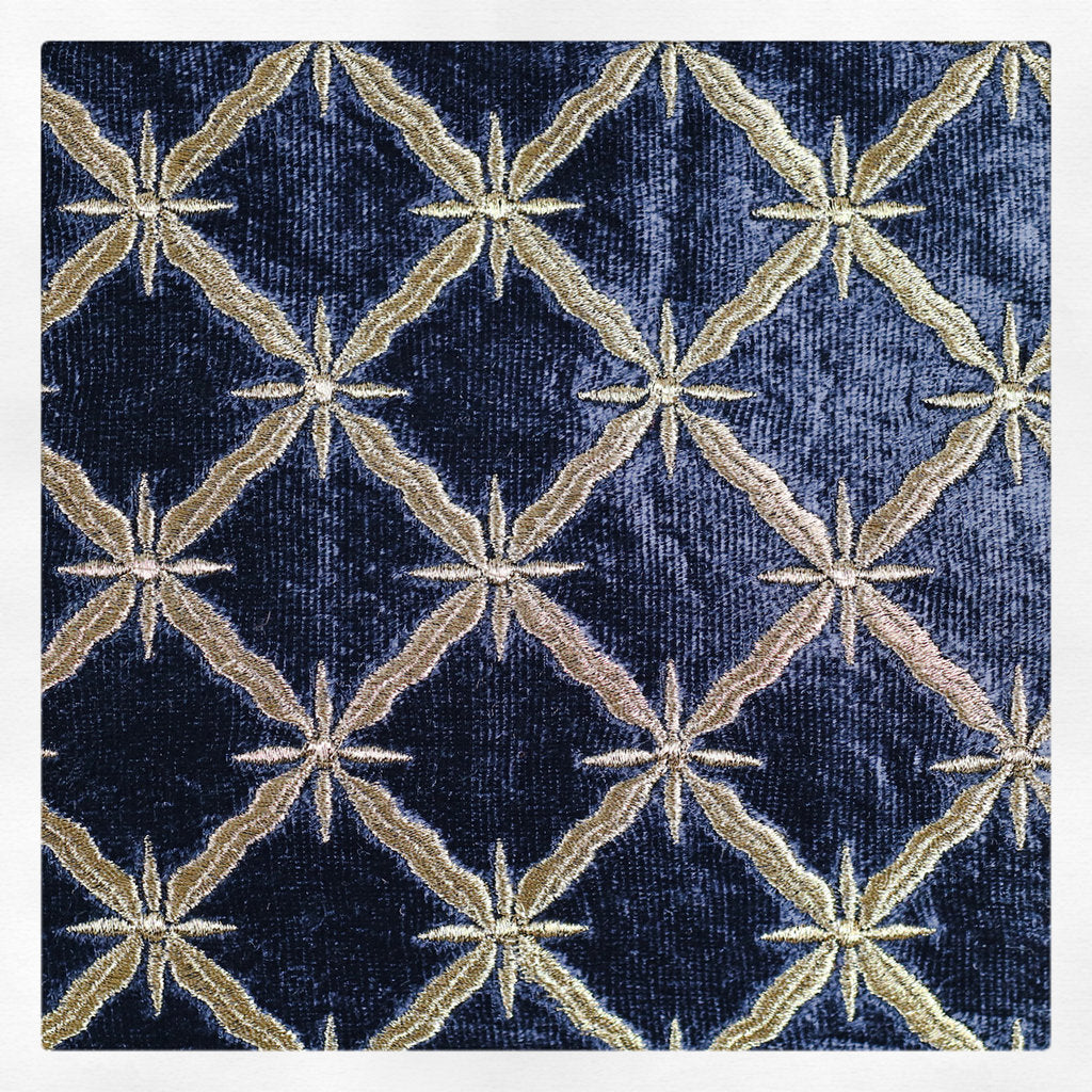 Detalj av kuddfodral med svart botten med ett broderat gyllene mönster