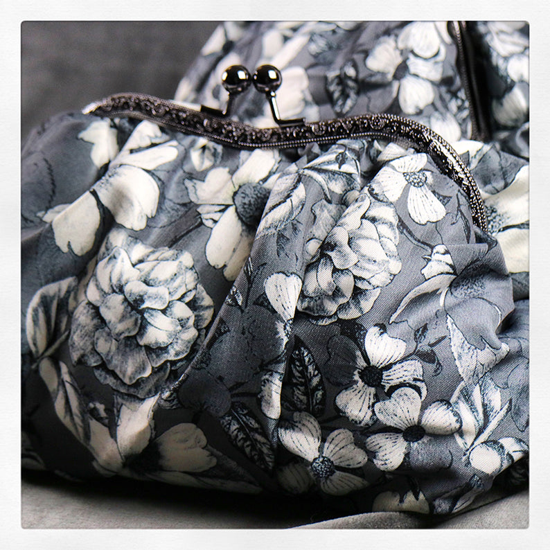 Fluffig och pösig necessär i gråa toner med blommor.