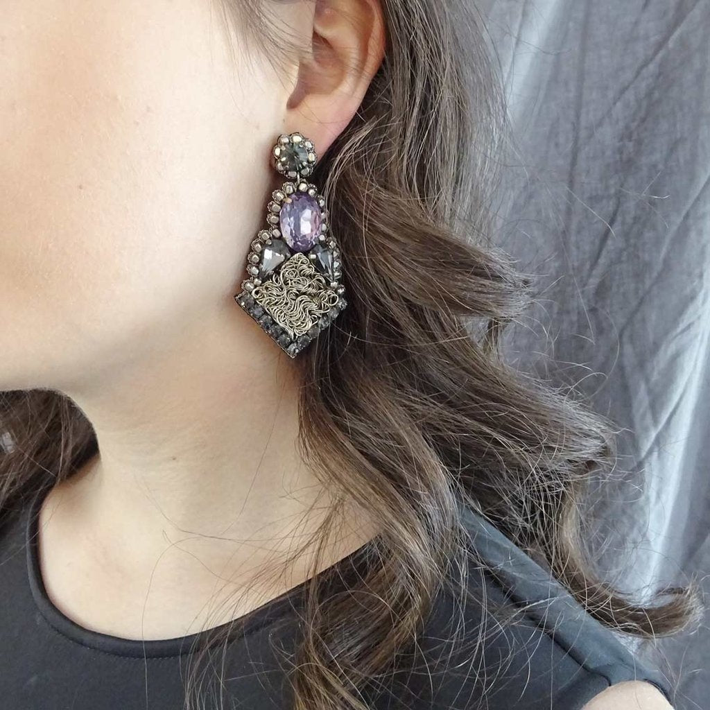 Stora öränge med glaskristaller i örat på en kvinna