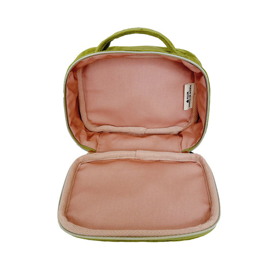 En öppen grön sammets necessär med handtag. Fodret är rosa.