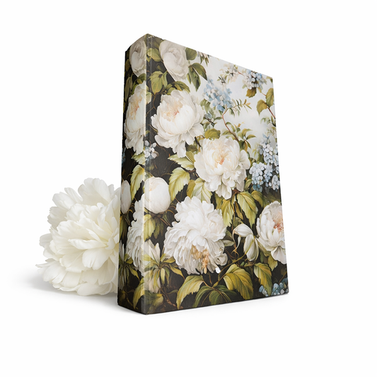 Boklåda som är dekorerad med ett siden liknande material med Pioner, blommor och blad. En vit Pion ligger bakom boken.