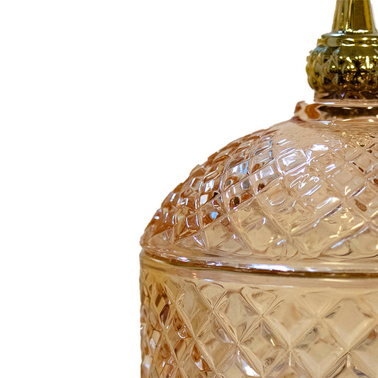 Detalj av rund glasburk med gyllene topp.