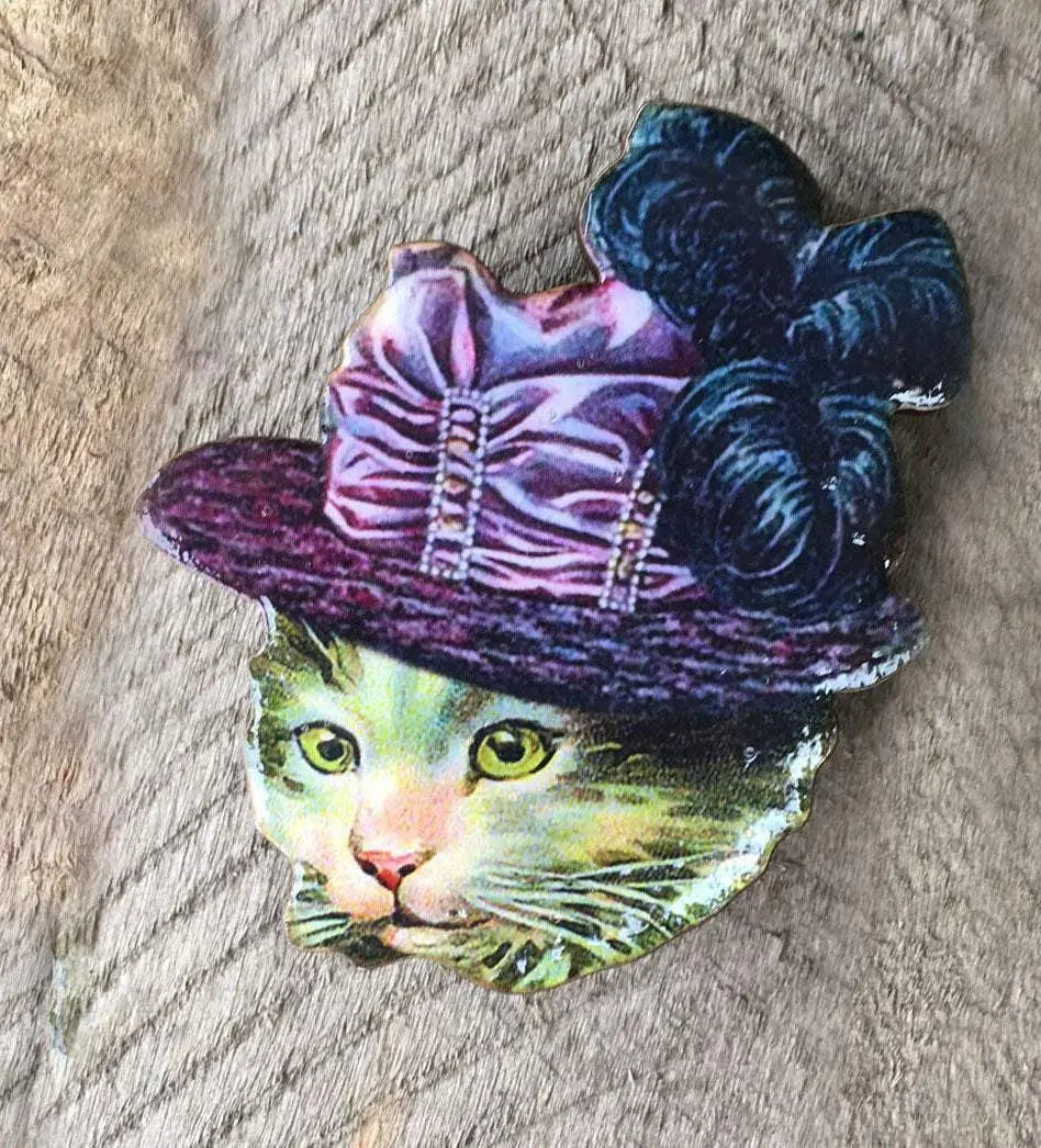Brosch med en katt i hatt