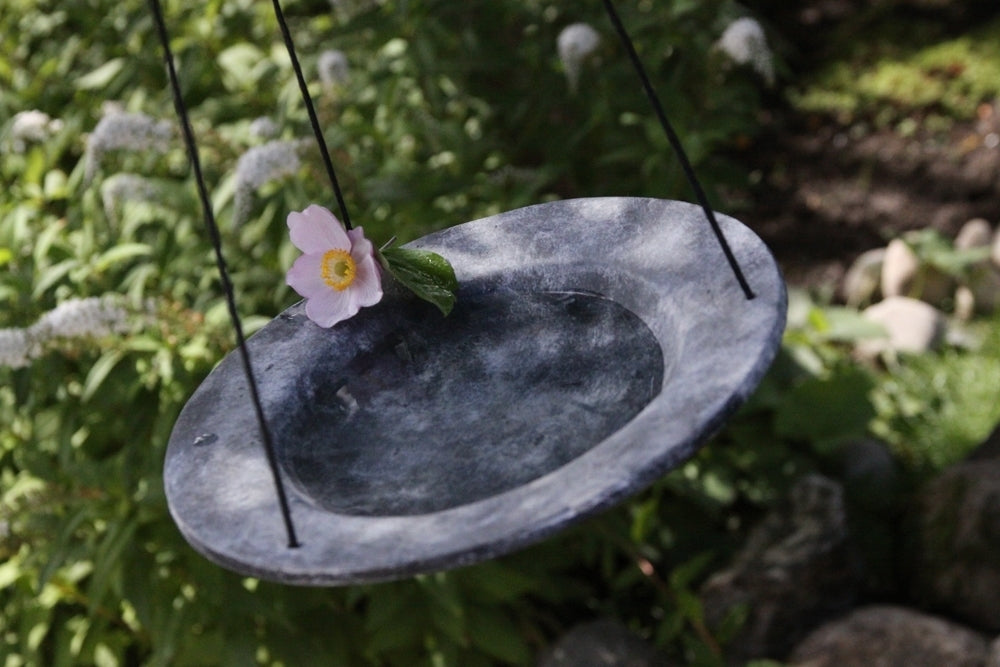 Hängande grått fågelbad med blomma