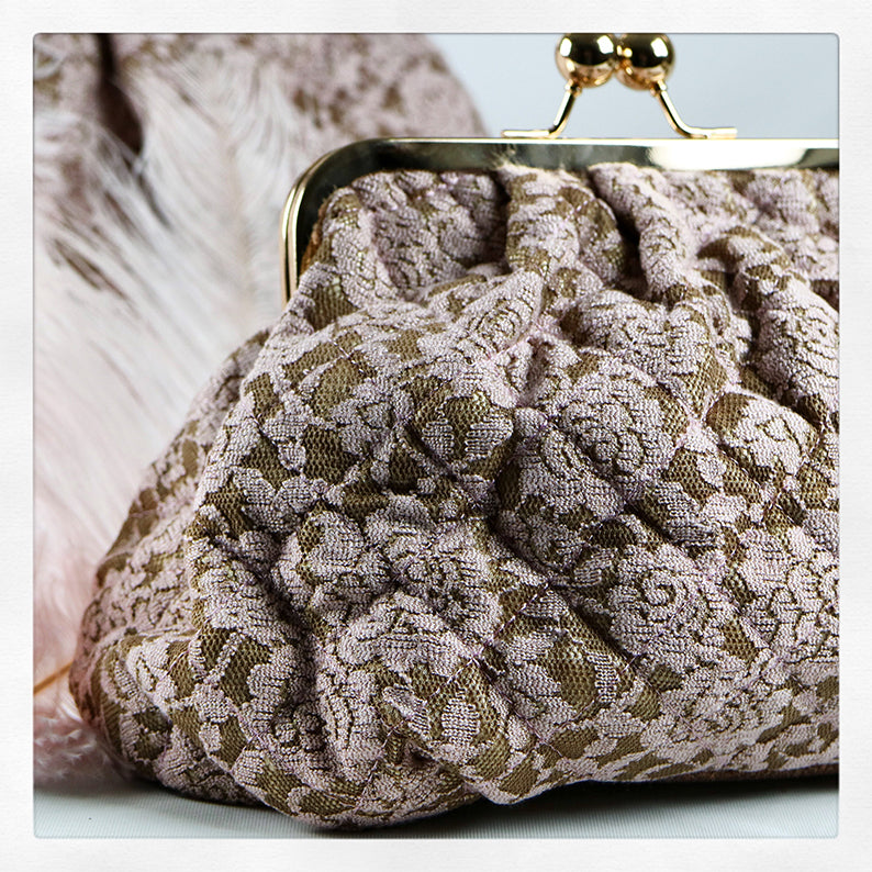 En necessär med en beige botten som täcks av en rosa spets 