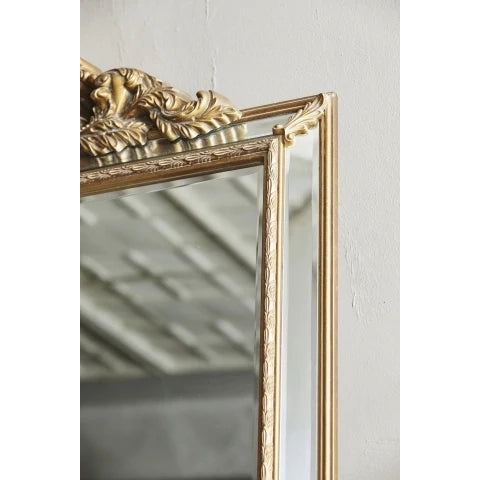 Detalj av spegel med ornament i guldfärg